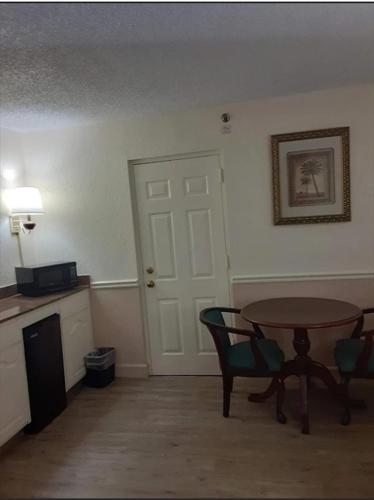 a room with a table and chairs and a door at Royal Suites Baton Rouge near LSU and Airport in Baton Rouge