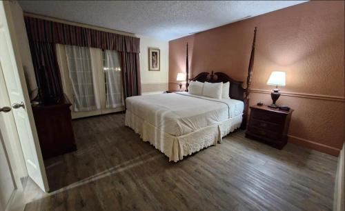 a bedroom with a large bed in a hotel room at Royal Suites Baton Rouge near LSU and Airport in Baton Rouge