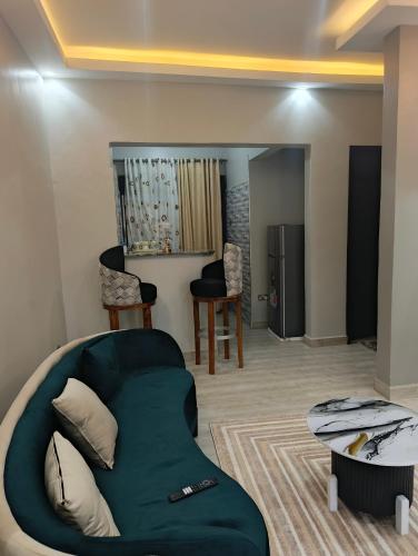 a living room with a green couch and chairs at Nsuube Apartment in Mukono