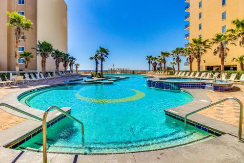 a swimming pool with palm trees and a building at Crystal Tower 2006 in Gulf Shores