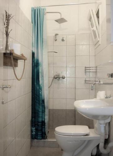 a bathroom with a shower and a toilet and a sink at Boho Center Studio in Keramoti