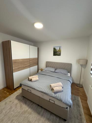 a bedroom with a large bed with two pillows on it at ZORA apartmani Sarajevo in Sarajevo
