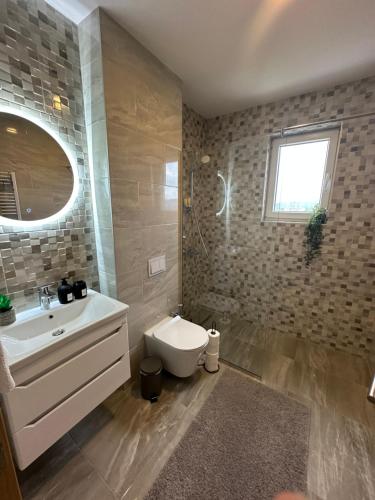 a bathroom with a sink and a toilet and a window at ZORA apartmani Sarajevo in Sarajevo