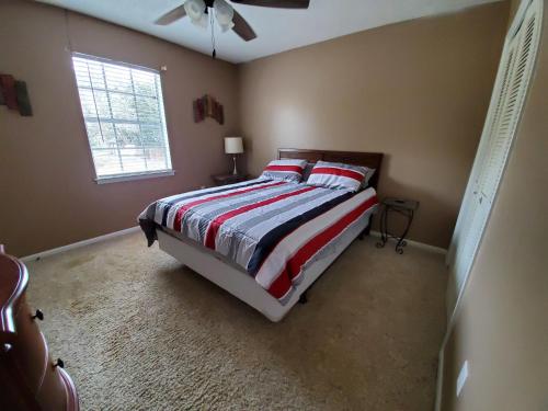 a bedroom with a bed with a red and white striped blanket at 4br Coastal Home I Sleeps 12 I Dock & Firepit in Gautier