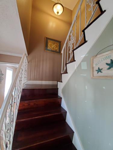 a staircase in a home with white railings and wood floors at 4br Coastal Home I Sleeps 12 I Dock & Firepit in Gautier