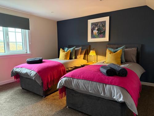 a bedroom with two beds with pink and yellow pillows at Sea Room, Scalpay in Scalpay