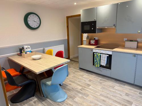 a kitchen with a table and a clock on the wall at Sea Room, Scalpay in Scalpay