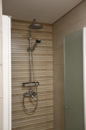 a shower with a shower head in a bathroom at Albergue Ultreya in Esposende