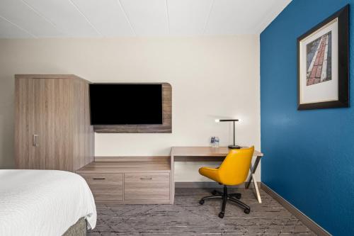 a hotel room with a bed and a desk with a television at Holiday Inn Express Boston North-Woburn by IHG in Woburn