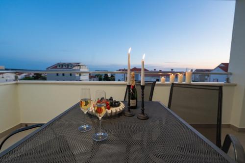 a table with two glasses of wine and a cake at Pool and Breakfast Apartments Villa Maro in Novalja