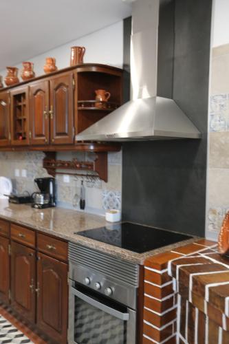 a kitchen with wooden cabinets and a stove top oven at Albergue Ultreya in Esposende