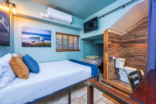 a bedroom with a bed and a wooden wall at Nomads Hotel in San Clemente