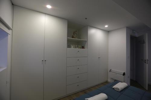 a bathroom with white cabinets and a blue bed at Albergue Ultreya in Esposende