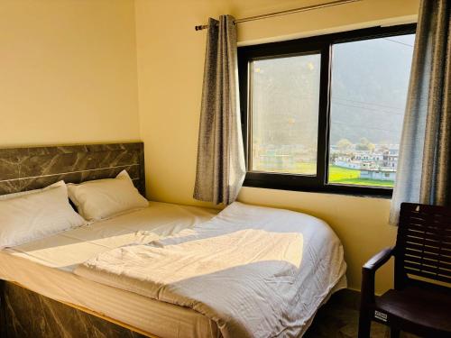 a bedroom with two beds and a window at Juyal palace in Jāmb
