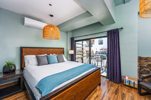 a bedroom with a bed and a balcony at Nomads Hotel in San Clemente