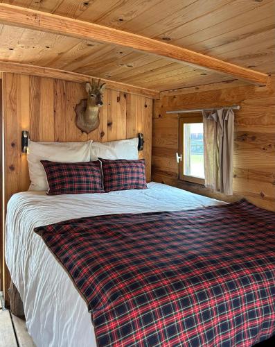 a bed in a log cabin with a deer head on the wall at Toue cabanée romantique - Vue Maine et Château - Centre Angers in Angers