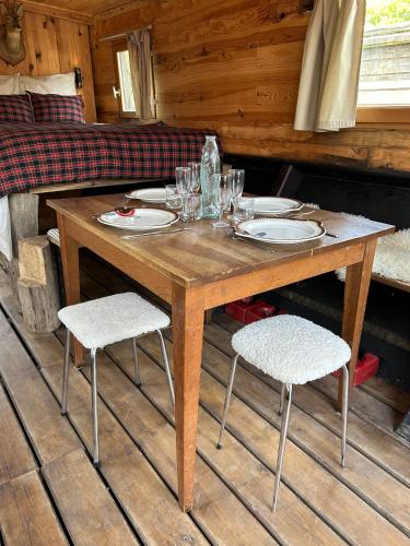 a wooden table with plates and glasses on it at Toue cabanée romantique - Vue Maine et Château - Centre Angers in Angers