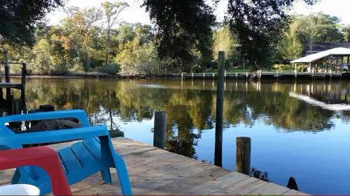 a bench sitting on a dock next to a lake at 4br Coastal Home I Sleeps 12 I Dock & Firepit in Gautier