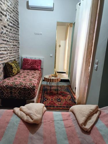 a room with a bed and a couch and a table at Dar Le Monde in Marrakech