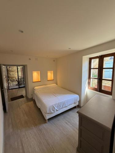 une chambre avec un lit et deux fenêtres dans l'établissement Maison entre mer et montagne à Canari, à Canari