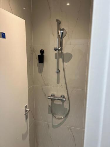 a shower with a shower head in a bathroom at Y Hostel in Amsterdam