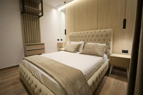 a bedroom with a large bed with white sheets and pillows at Apartments Romario in Sarandë