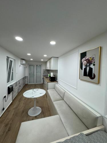 ein Wohnzimmer mit Sofa und Tisch in der Unterkunft Studio 032 in Prčanj