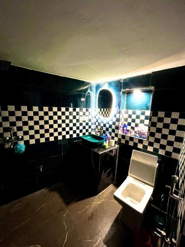 a bathroom with a black and white checkered wall at Shafar Manzil in Jaipur