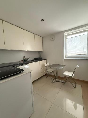 a kitchen with white cabinets and a table and chairs at Apartment in Berlin with terrace1 in Berlin