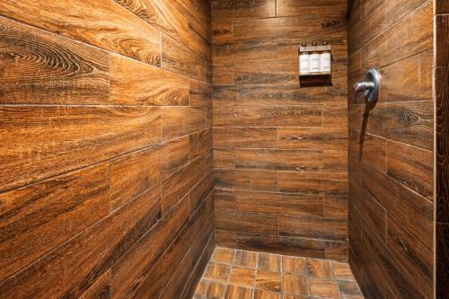 a bathroom with wooden walls and a shower at Nomads Hotel in San Clemente