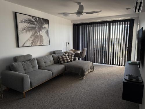 a living room with a couch and a table at Loft Rockhampton in Rockhampton
