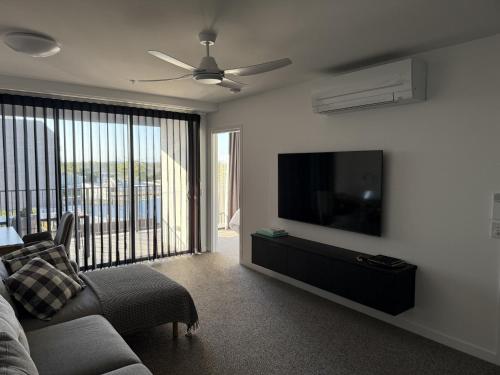 a living room with a couch and a flat screen tv at Loft Rockhampton in Rockhampton