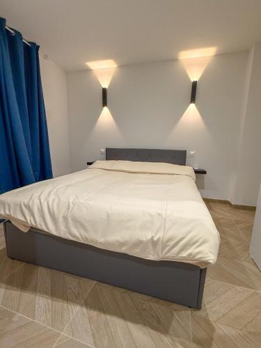 - une chambre avec un lit et deux lumières sur le mur dans l'établissement T2 luxe 100 m port, Clim, Wi-Fi, à Toulon