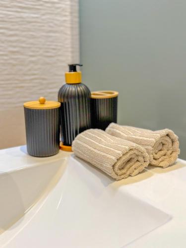 un évier blanc avec une bouteille et des serviettes dessus dans l'établissement T2 luxe 100 m port, Clim, Wi-Fi, à Toulon