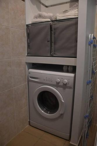 - un lave-linge et un sèche-linge dans une petite salle de bains dans l'établissement Studio de Julien, à Châtenay-Malabry