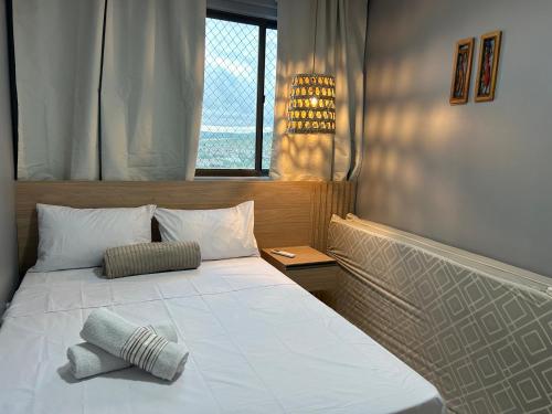 a bedroom with a large white bed with a window at Perfeito Ap Caruaru in Caruaru