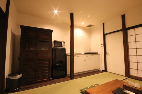 a kitchen with a black refrigerator and a microwave at Hashiba-an in Kanazawa