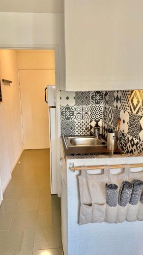 une cuisine avec un évier et une cuisinière four supérieur dans l'établissement Studio Calme et Confort - Saint-Cyprien - Pont Neuf, à Toulouse