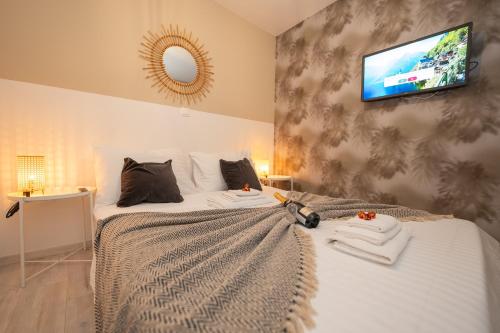 a bedroom with a bed with a tv on the wall at Pool and Breakfast Apartments Villa Maro in Novalja