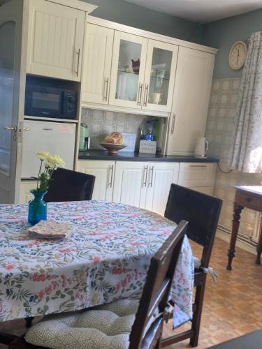 a kitchen with a table and white cabinets and a table and chairs at House Six Bed 4km from Limerick City Centre in Limerick