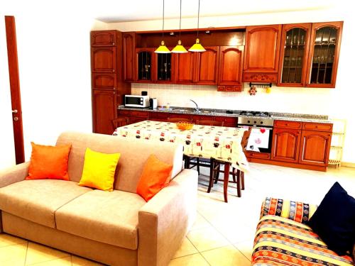 a living room with a couch and a kitchen with a table at Da Adry e Lodo in Settimo San Pietro