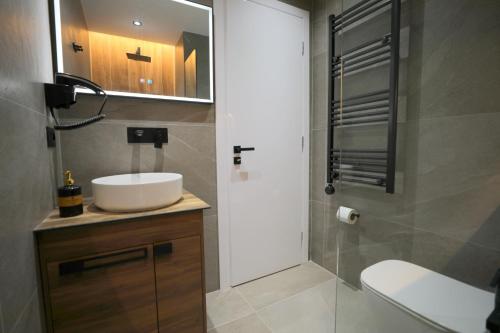 a bathroom with a sink and a toilet and a mirror at Apartments Romario in Sarandë