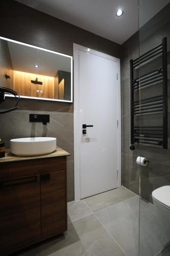 a bathroom with a sink and a toilet and a mirror at Apartments Romario in Sarandë