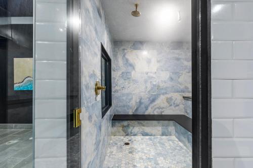 a bathroom with a walk in shower next to a door at The Armon Stamford Hotel & Conference Center in Stamford