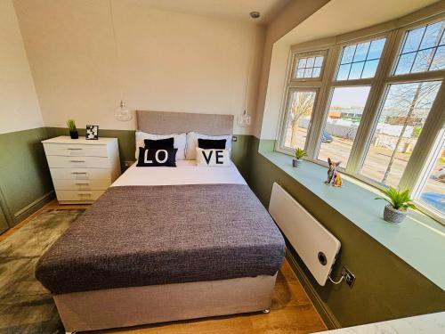 a bedroom with a large bed and two windows at Luxury standard flats in Central London, ideal for tourists in Northolt