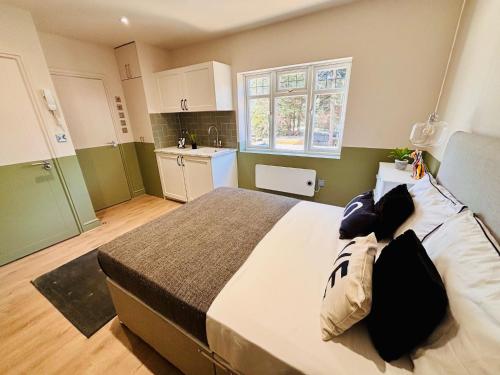 a bedroom with a large bed and a kitchen at Luxury standard flats in Central London, ideal for tourists in Northolt