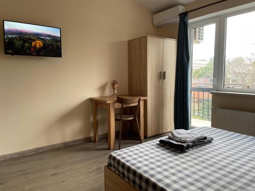 a bedroom with a bed and a desk and a window at Гостьовий будинок Arсadia in Odesa