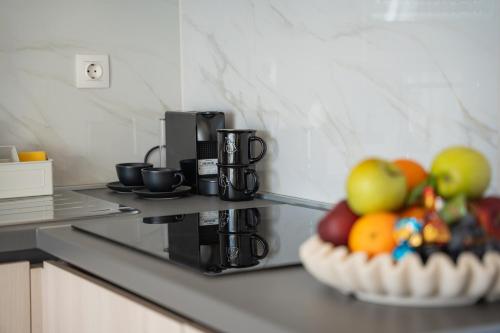 a kitchen counter with a bowl of fruit and a coffee maker at Pool and Breakfast Apartments Villa Maro in Novalja