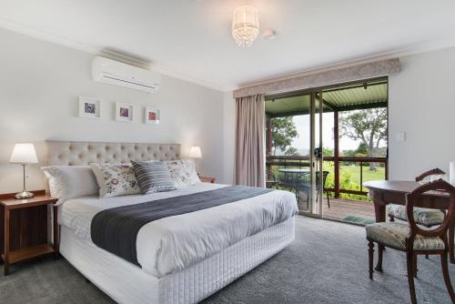 a bedroom with a bed and a desk and a window at Shambhala Guesthouse in Bridgetown