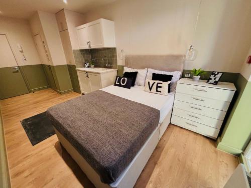 a bedroom with a large bed and a kitchen at Luxury standard flats in Central London, ideal for tourists in Northolt